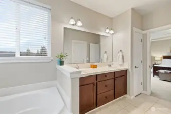 Primary bathroom with soaking tub, double sinks and linen storage closet.