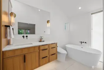 Luxurious primary bathroom with soaking tub, heated floors, bidet and dual head shower