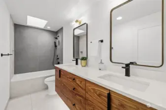 Full bathroom on the upper level with dual sinks, heated tile floors and quart counters