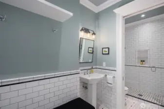 The lower level bathroom offers entry from both inside and out making this the perfect changing room with bench and storage for pool days.