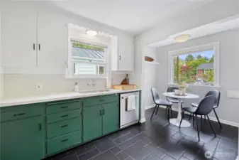 A modern kitchen with stainless steel appliances, an eating nook, and quartz countertops.