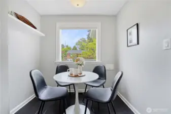 A modern kitchen with stainless steel appliances, an eating nook, and quartz