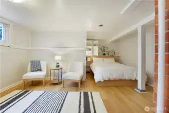 Enormous lower level bedroom with sitting area has high ceilings.