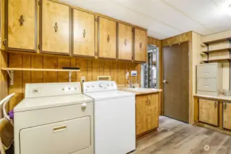 The laundry room comes with the washer and dryer as well as a utility sink and a ton of cabinets.  The kitchen is through the open door.