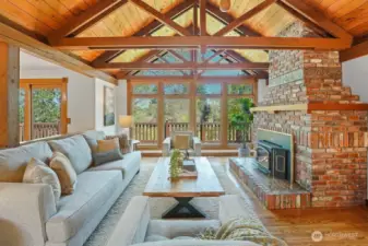 Soaring Vaulted cedar ceilings and a cozy wood-burning fireplace crate a warm, inviting living space