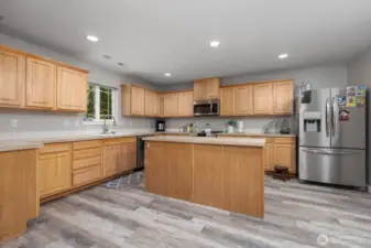 Enjoy cooking in this well-appointed kitchen with ample cabinetry, stainless appliances, expansive counter space, and a generous island perfect for food prep or casual dining.
