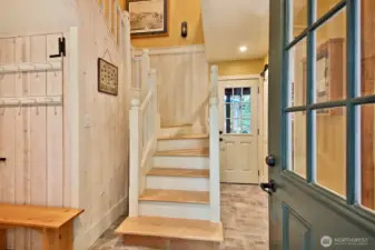 Upon entry, floors are brick patten tile. Turn left to enter the kitchen/living area and Primary Suite. To the right for the garage. Main level half bath is along the right side of this hallway. Door straight ahead is to your covered backyard deck.