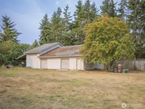 Impressive 2,400 sq. ft. detached shop/garage w/ RV parking, 12' x 12' door, 39' depth, manual hoist for lifting items to loft, 3 bays & carport.