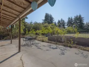 Low-maintenance concrete patio with partial cover, ideal for hosting family and friends.