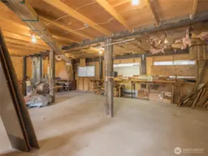With built-in shelving, multiple workbenches, and ample floor space, the shop/garage is ideal for woodworking, mechanical work, or hobby crafting.