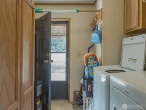 Well-positioned for everyday convenience, the laundry room offers three points of access — from the kitchen, hallway, and directly to the exterior.