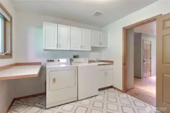 Now THIS is a laundry room! Commercial Washer and Dryer included (dryer even has the coin slots!) makes laundry a breeze. Large window, folding table, cabinets, utility sink, hamper down from Primary Suite and THREE closets for storage!