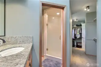 Primary ensuite bath view two showing your shower and water closet with toilet and pocket door, one of your walk-in closets to your right.