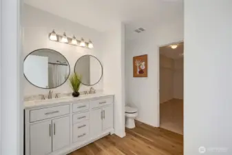 Primary ensuite features a double vanity, new lighting, and modern finishes.