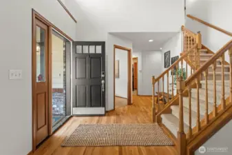 Front door opens to entryway with beautiful hardwood floors.