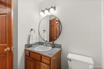 Main floor half bathroom with updated fixtures, mirror, and hardware.
