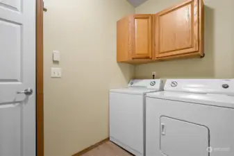 Washer and dryer stay in laundry room with cabinet space, leading to attached two-car garage.