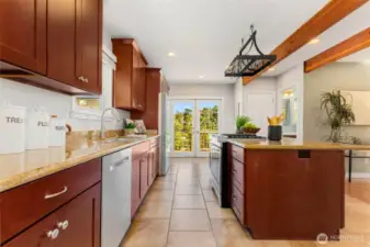 Enormous kitchen with granite tile counters, custom cherry cabinets, and matching stainless appliances