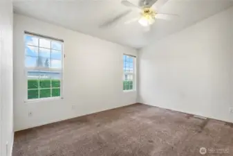 The primary bedroom offers 2 windows (with blinds) and a ceiling fan.