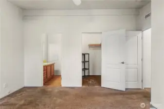 A view from of the primary bedroom looking toward the attached (en suite) bathroom and walk-in closet.