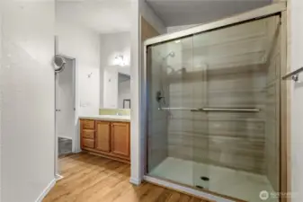 Large low step shower and vanity in primary bathroom.