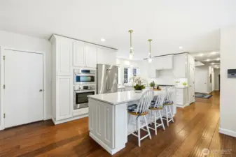 Open-concept kitchen with island seating and hardwood flooring flowing effortlessly into the main living areas of this Lake Forest Estates home.