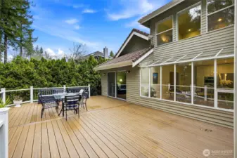 Rear exterior showcasing full-length Trex deck, multiple slider access points, and seamless indoor-outdoor living in this Lake Wilderness estate.