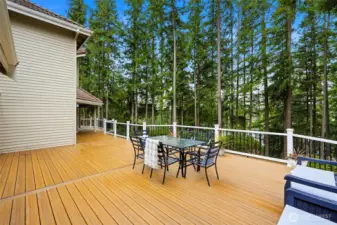 Private deck seating area overlooking mature trees and Lake Wilderness—ideal for outdoor dining and entertaining.