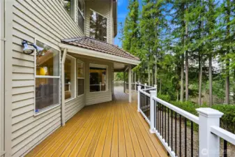 Covered deck entry with slider access connecting interior living spaces to outdoor entertaining areas in this Maple Valley lake view home.