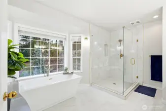 Updated spa-inspired primary bathroom featuring soaking tub, walk-in shower, modern finishes, and abundant natural light in this Lake Wilderness view home.