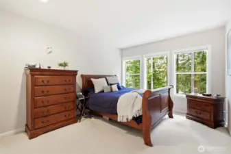 Spacious secondary bedroom with large windows and peaceful wooded views, perfect for guests or family in this 4-bedroom Maple Valley home.