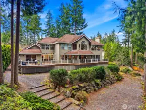 Full rear exterior view highlighting the expansive 1,400 sq ft Trex deck, multiple slider access points, and seamless indoor-outdoor entertaining design.