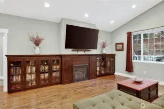 Great room with custom built-in shelving hugging a propane fireplace.