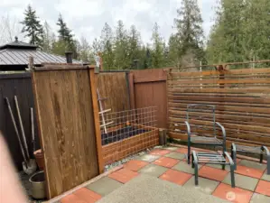 Custom paver patio with privacy fencing, raised garden bed and viiew to the forest to the East