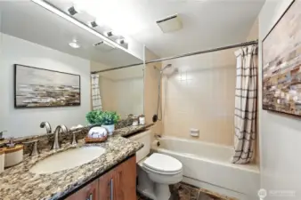 Updated guest bath with tile & slab granite vanity.