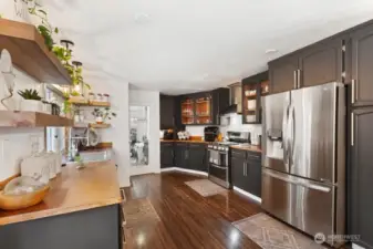 Well-Appointed Kitchen – Thoughtfully updated with display cabinets, generous counter and storage space, stainless steel appliances, a Bosch ultra-quiet dishwasher, built-in microwave drawer, and stylish open shelving.