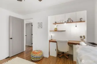 The third bedroom features a custom closet converted office with live edge desk.