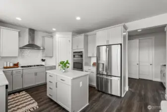Stainless steel appliances offset the white cabinetry adding a modern flare to this well used room. A walk in pantry next located next to the oven provides a place for your cooking essentials at hand.