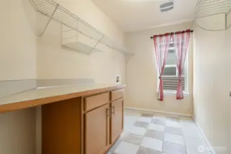 Laundry made easier with a full room, storage cabinets, and folding space