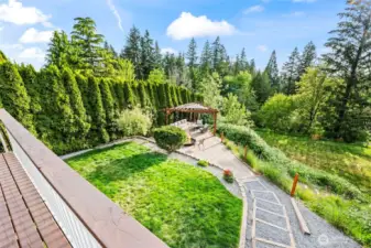 Looking down from the deck to the entertaining space with gazebo and firepit