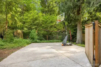 Newly relaid concrete pad—ideal for boat or RV parking, or as a spacious basketball area with netting to keep the ball in play. Features a wide, gated fence for easy access!