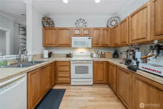 Kitchen as seen from laundry room. Half bath and entryway seen to the left.