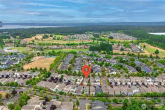 Arial view of the neighborhood. This home is under the flag. You are seeing the back of the home with garage access in the alley. On the left is Edgewater Park. Beyond is The Golf Club At Hawks Prairie.
