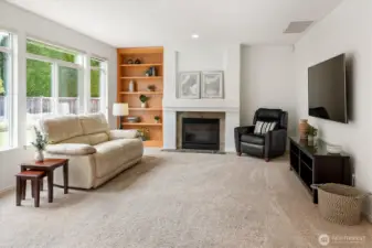 Relax in family room off kitchen made cozy with gas fireplace and built-in shelving