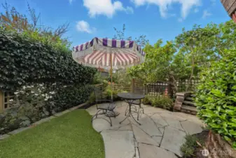 Lovely patio area next to the deck. Easy maintenance here with artificial grass.