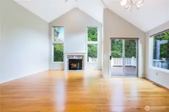 Vaulted ceilings, real hardwood floors, brand-new windows, a private deck, and a warm wood fireplace come together to make this living area truly inviting.