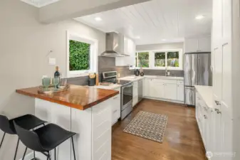 Behold the remodeled kitchen with breakfast bar and charming original shiplap ceiling