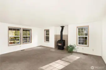 Living room with wood burning fireplace and tons of sunshine.