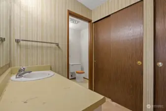 There are 2 walls of closets and a single sink vanity outside of the shower/toilet room.