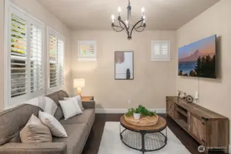 Space off the kitchen staged as a living room but could be formal dining room, office or playroom.